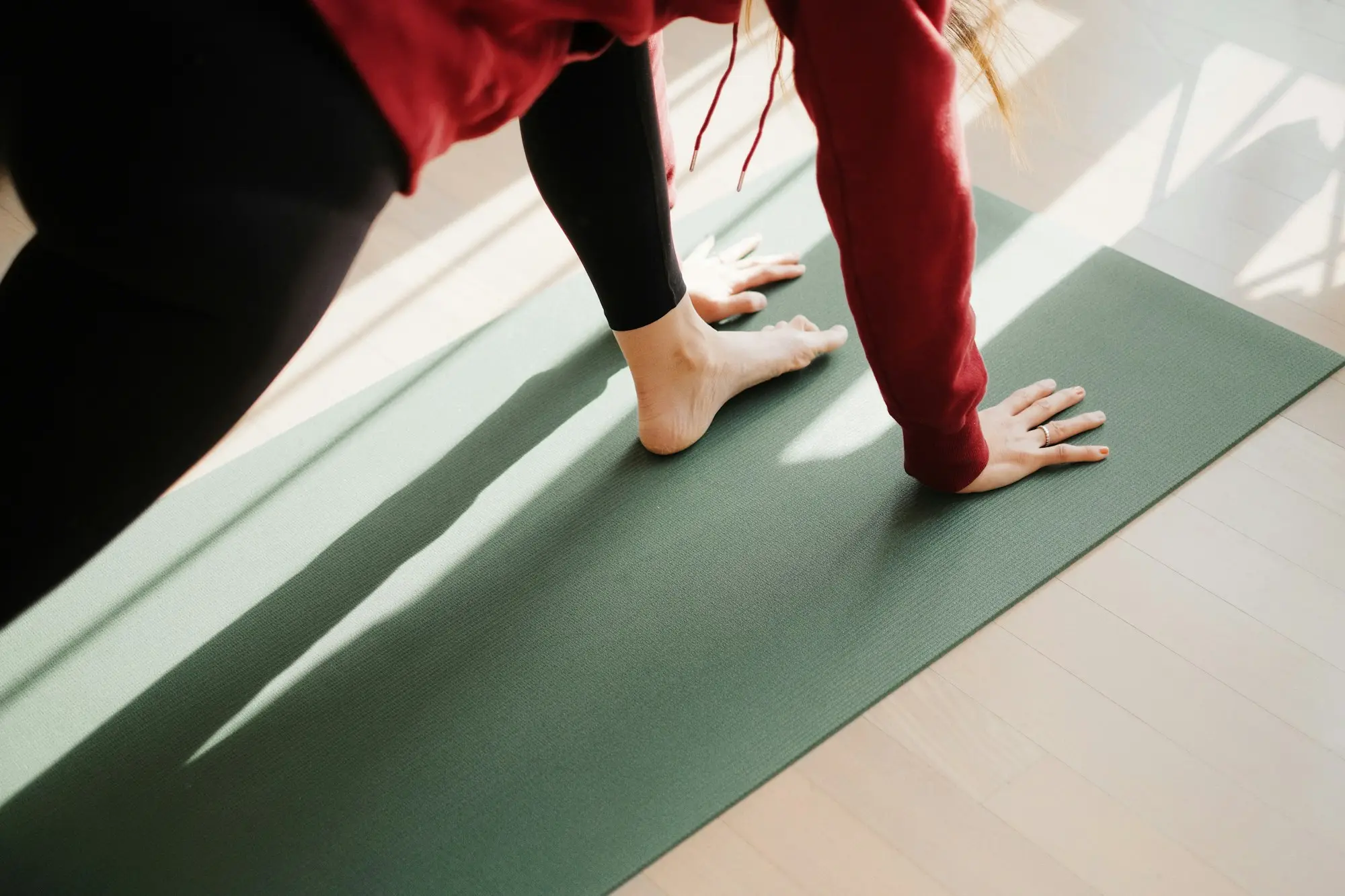 Tapis de Pilates vert déroulé au sol, prêt pour une séance à la maison