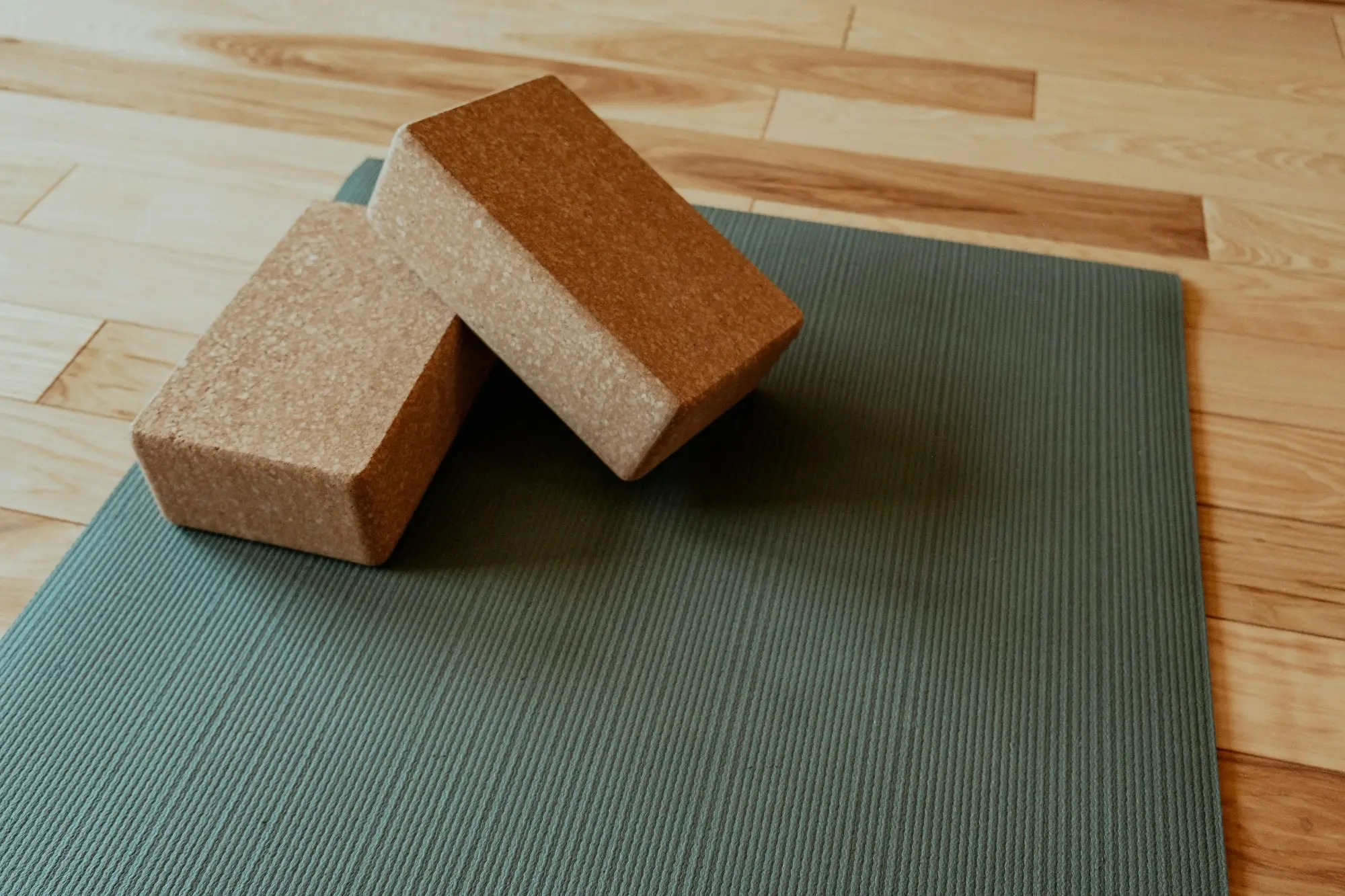 Deux blocs de yoga et un tapis installés près d'une fenêtre